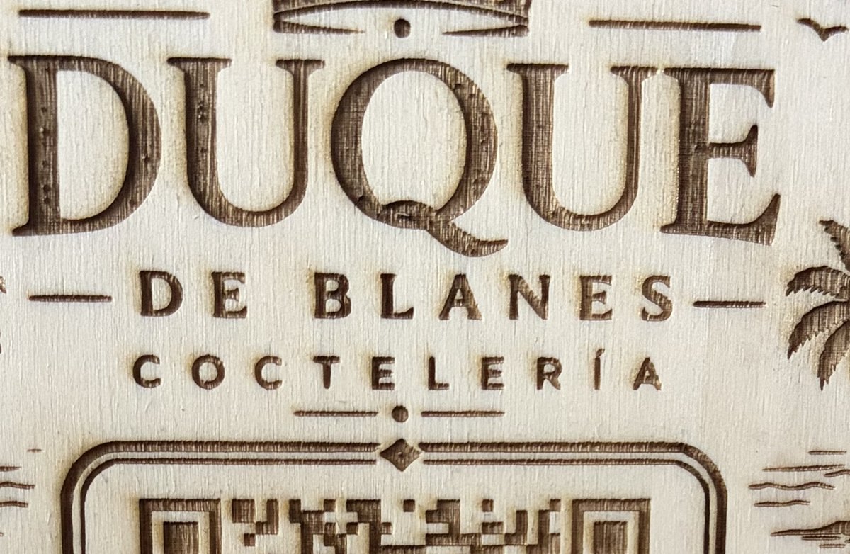 Detalle ampliado del grabado láser sobre madera de una placa QR
